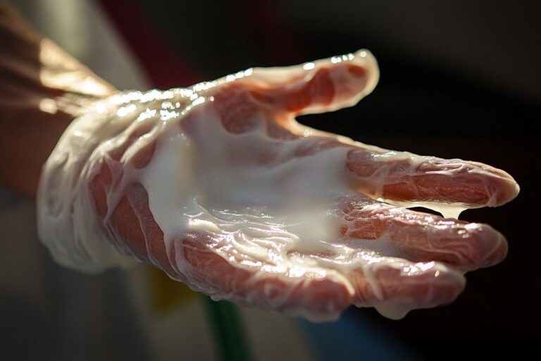 Main gantée recouverte de crème blanche