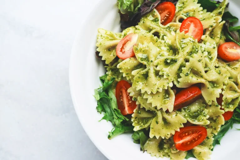 Assiette de farfalles au pesto avec tomates cerises et salade verte